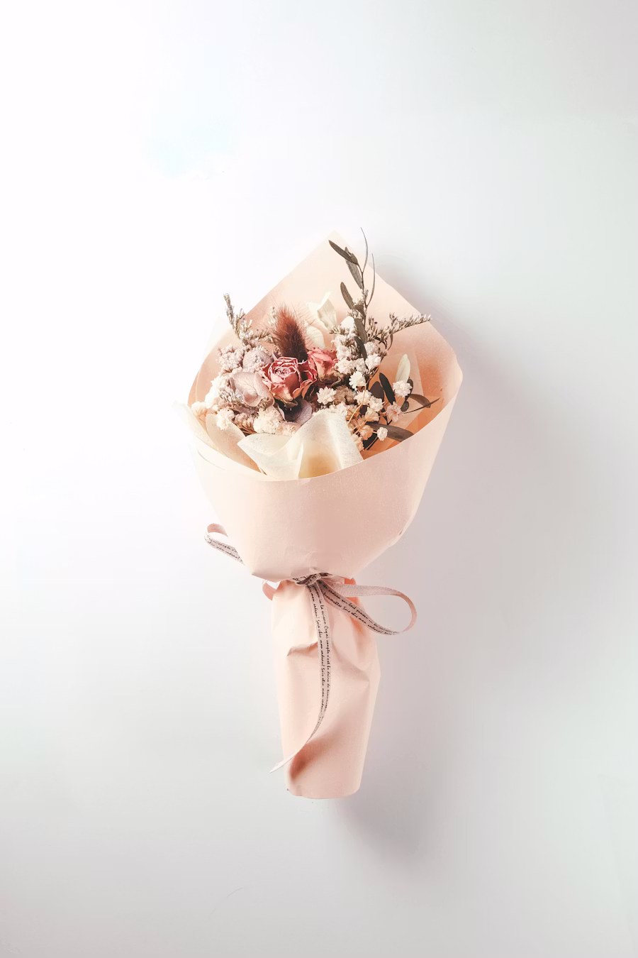 Petit bouquet d'hiver tons rose poudré, fleurs séchées dans papier rose pâle